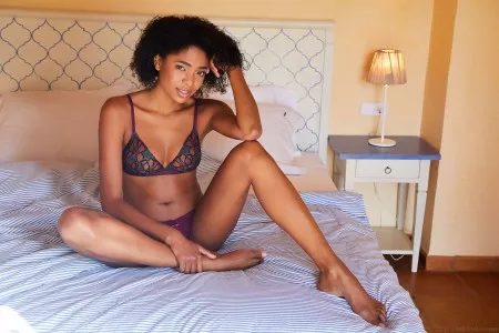 Счастливая африканская модель в спальне